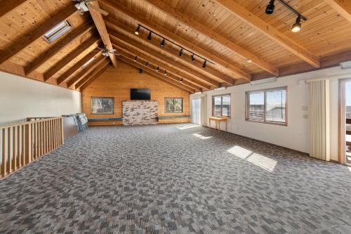 a large room with wooden ceilings and a flat screen tv at Harbor Lite Lodge in Fort Bragg