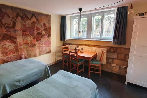 een kamer met 2 bedden, een tafel en een raam bij Villa Haniel Apartment Frieda in Dresden