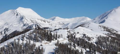 a snow covered mountain with a ski lodge on it at Pension & Appartements Ronacherhof -Mountain Hideaway Slopeside in Bad Kleinkirchheim