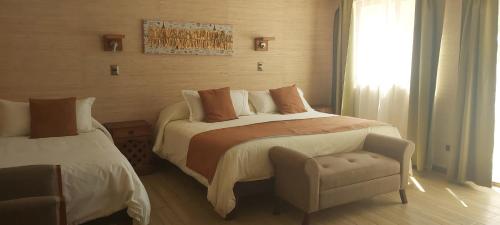 1 dormitorio con 1 cama, 1 silla y 1 ventana en Las Montañas de Olmué Resort & Conference Center, en Olmué