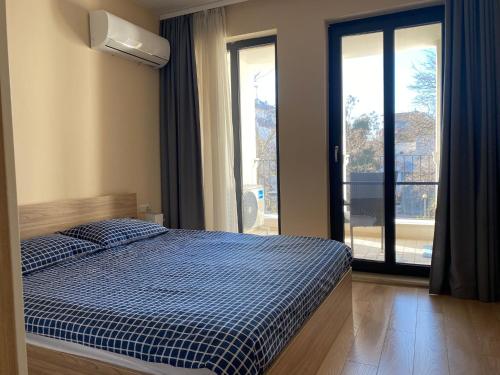 ein Schlafzimmer mit einem Bett und einem großen Fenster in der Unterkunft Brand new apartment with outdoor swimming pool in Warna