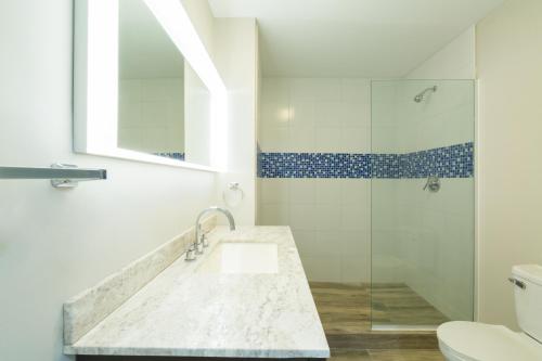 uma casa de banho com um lavatório e um chuveiro em The Tides, Grace Bay em Providenciales