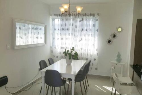 a white dining room with a white table and chairs at Moderno Apartamento amueblado Full 3 habitaciones, wifi, Netflix in Santiago de los Caballeros