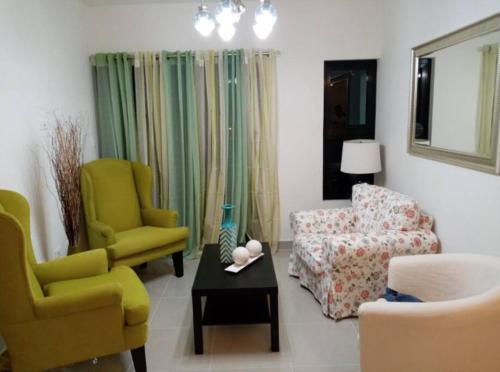 a living room with two chairs and a couch at Moderno Apartamento amueblado Full 3 habitaciones, wifi, Netflix in Santiago de los Caballeros