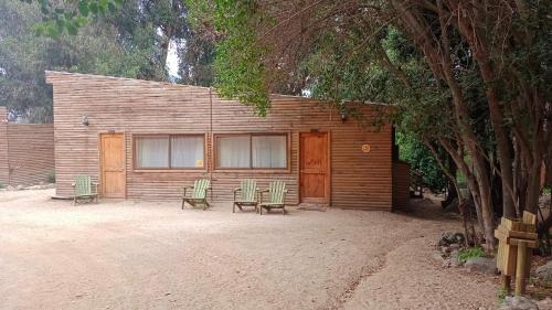 a building with two chairs and a bench in front of it at Las Montañas de Olmué Resort & Conference Center in Olmué
