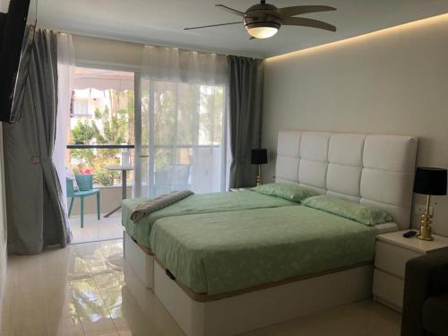 a bedroom with a large bed and a balcony at First Line Seaview Apartment in Adeje
