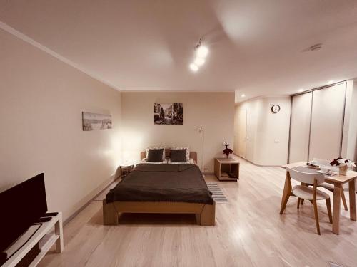 a bedroom with a bed and a tv and a table at Apartment128 in Valmiera