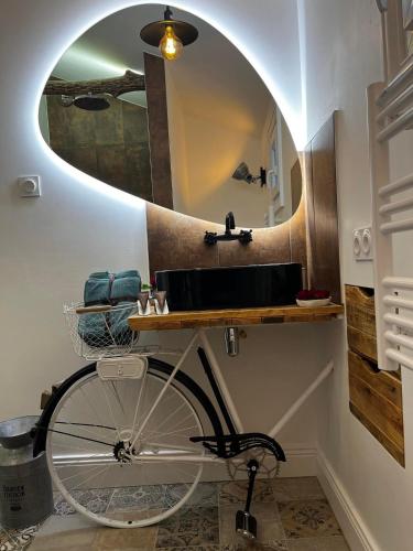 a bike parked in a bathroom with a mirror at Le Maréchal Duplex - Appartement avec Jacuzzi - CAEN hyper Centre in Caen