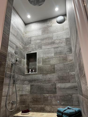 a bathroom with a shower with a tile wall at Le Maréchal Duplex - Appartement avec Jacuzzi - CAEN hyper Centre in Caen