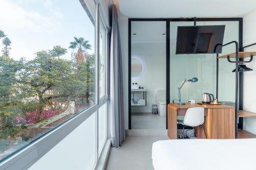 a bedroom with a large window and a desk at Flatguest RoomTiques Private Rooms in Las Palmas de Gran Canaria