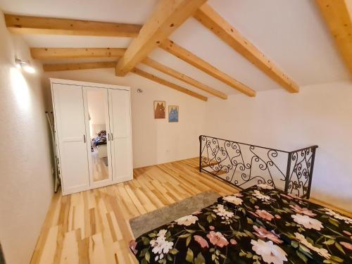 a bedroom with a bed in a room with wooden floors at Sweet House and Apartment in Rovinj