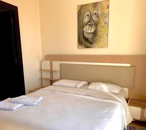 1 cama en un dormitorio con una pintura en la pared en Sab 9 - Great View Over Hassan Mosque. Luxurious 3 Bedrooms & 2,5 Bathrooms en Casablanca