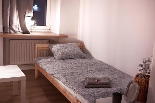 a small bedroom with a bed with a purse on it at Calm and quiet apartments in Szczecin in Szczecin