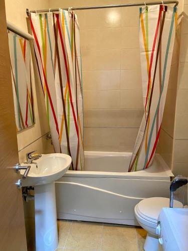 La salle de bains est pourvue d'une baignoire, d'un lavabo et de toilettes. dans l'établissement RIO 1, à Podgorica