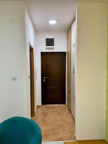 un couloir avec une porte marron et une chambre dans l'établissement RIO 1, à Podgorica