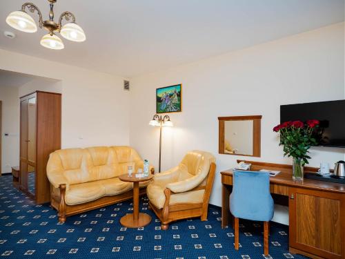 a hotel room with chairs and a table and a desk at Hotel Liptakówka in Białka Tatrzanska