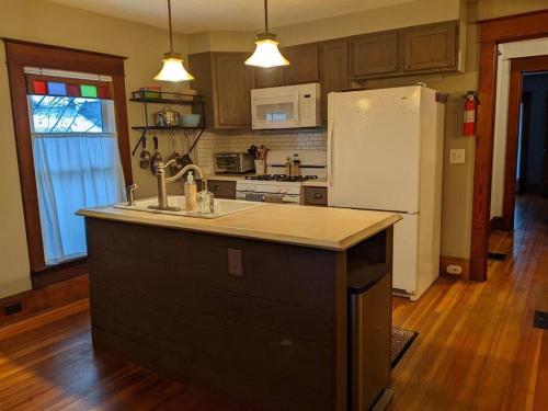 a kitchen with a white refrigerator and a counter top at Large Bakery Apartment - Central Downtown Location in Fredonia