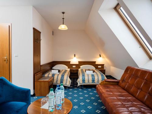 a hotel room with two beds and a couch at Hotel Liptakówka in Białka Tatrzanska