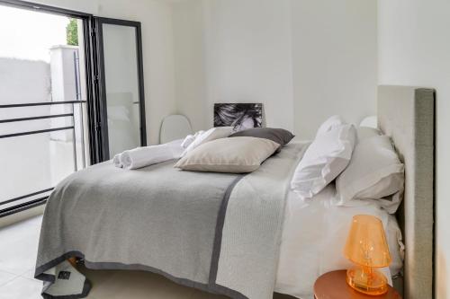 une chambre blanche avec un lit avec une fenêtre dans l'établissement IMMOGROOM- Modern - Elegant - Close to the beach -AC, à Cannes