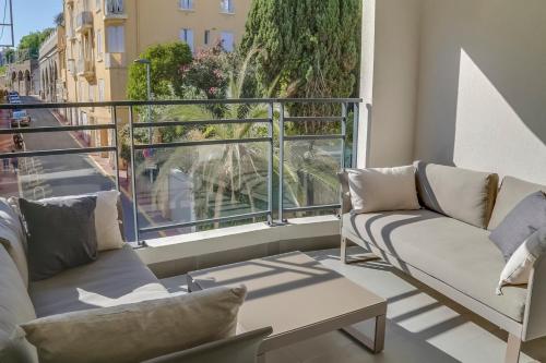 d'un balcon avec des canapés et une vue sur la rue. dans l'établissement IMMOGROOM- Modern - Elegant - Close to the beach -AC, à Cannes