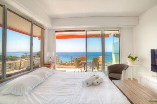 um quarto com uma cama grande e vista para o oceano em IMMOGROOM- 2 bedrooms -Panoramic Sea view - Huge Terrace - Beach em Cannes