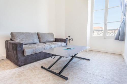 a living room with a couch and a table at IMMOGROOM - Center - Modern - 10 min from Palais des Festivals in Cannes
