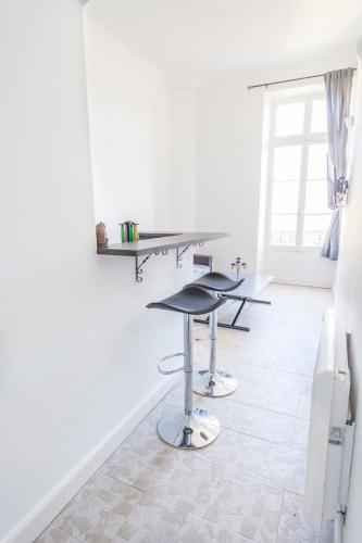 Cette chambre blanche dispose d'une table et d'un tabouret. dans l'établissement IMMOGROOM - Center - Modern - 10 min from Palais des Festivals, à Cannes