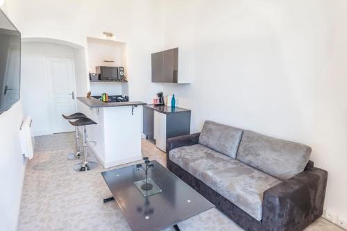 un salon avec un canapé et une cuisine dans l'établissement IMMOGROOM - Center - Modern - 10 min from Palais des Festivals, à Cannes