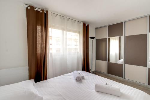 une chambre avec un lit blanc et un grand miroir dans l'établissement IMMOGROOM- Renovated - Wifi - Close to everything, à Cannes