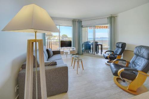 - un salon avec un canapé, des chaises et une lampe dans l'établissement IMMOGROOM -Panoramic sea view terrace-2min from the beach, à Cannes