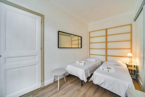 une chambre avec deux lits et un miroir dans l'établissement IMMOGROOM- Close to the Palais des festivals- Wifi, à Cannes