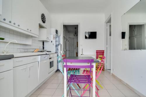 - une cuisine avec une table violette et des tabourets colorés dans l'établissement IMMOGROOM - Sea View - Balcony - 5 min from the beach - AC - Wifi, à Cannes