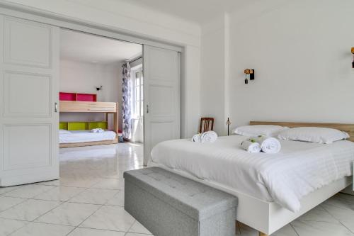 - une chambre blanche avec un grand lit et des draps blancs dans l'établissement IMMOGROOM - Sea View - Balcony - 5 min from the beach - AC - Wifi, à Cannes