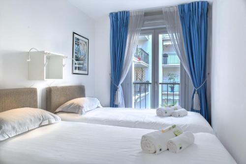 - 2 lits dans une chambre dotée de rideaux bleus dans l'établissement IMMOGROOM - 3min from beach - AC - 10min from Palais - Wifi, à Cannes