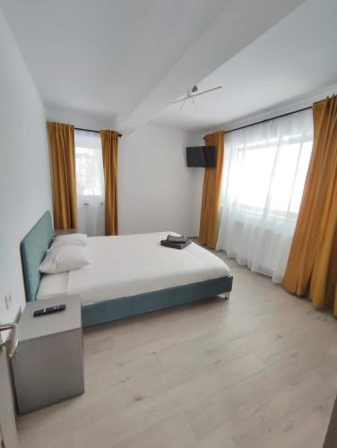 a bedroom with a large bed and windows at Mountain Break Azuga in Azuga