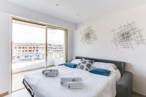 - une chambre avec un lit et une grande fenêtre dans l'établissement IMMOGROOM - Renovated apartment - Terrace - AC - Wifi, à Cannes