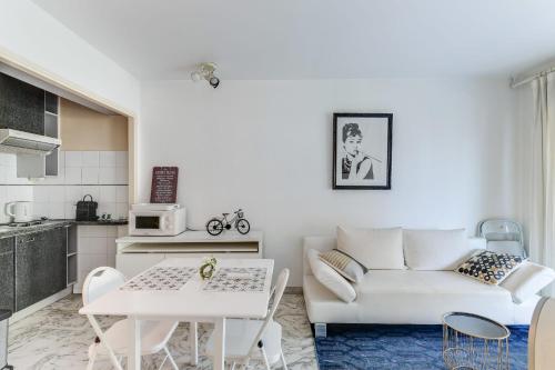 ein weißes Wohnzimmer mit einem Sofa und einem Tisch in der Unterkunft IMMOGROOM- Open view terrace - Parking - Next CROISETTE in Cannes