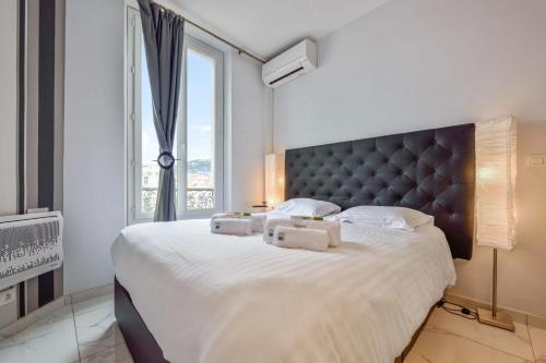 une chambre avec un grand lit avec une grande fenêtre dans l'établissement IMOOGROOM - Modern - City Center - AC - 9 min from the Palais, à Cannes