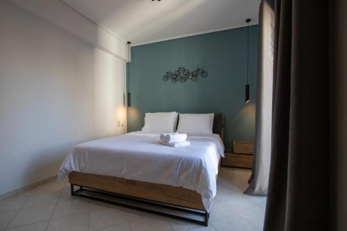 a bedroom with a bed with a blue wall at Petrino Suites Mesolonghi in Missolonghi