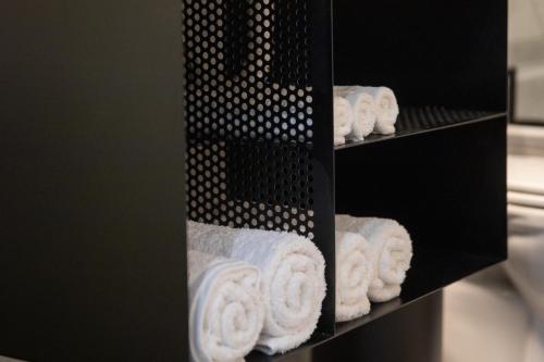 a bunch of towels on a shelf in a bathroom at Petrino Suites Mesolonghi in Missolonghi