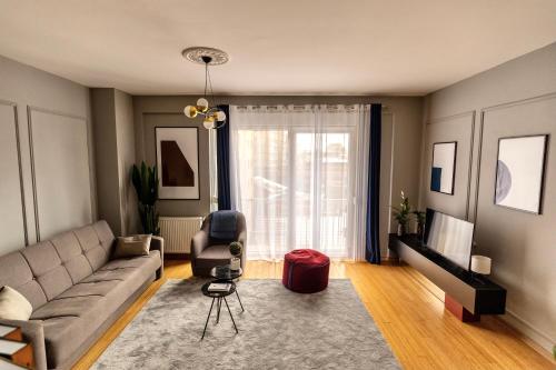 a living room with a couch and a television at Etern Stays - Urban Apartment in Pristina