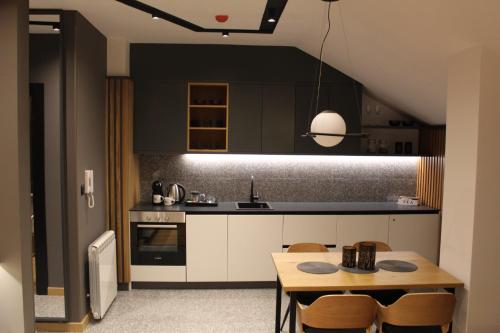 a kitchen with a table and a dining room at Modern mountain - Crown apartment in Kolašin