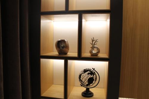 a display case with vases and lights in it at Modern mountain - Crown apartment in Kolašin
