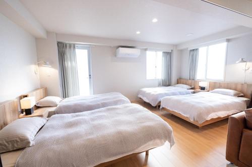 ein Hotelzimmer mit 3 Betten und Fenstern in der Unterkunft RESIDENCE HARIMAYA-Vacation STAY 99860v in Kōchi