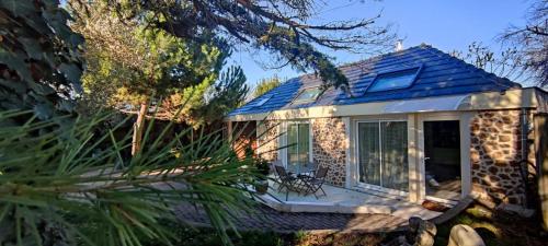 ein kleines Steinhaus mit einer Veranda und Fenstern in der Unterkunft Petite propriété de prestige entre Paris et Disneyland in Le Plessis-Trévise