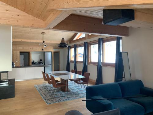 uma sala de estar com um sofá azul e uma mesa em CHALET Mitoyen LE RUSTICANA em Chamonix-Mont-Blanc