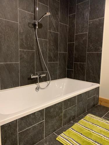 La salle de bains est pourvue d'une baignoire et d'une douche. dans l'établissement CHALET Mitoyen LE RUSTICANA, à Chamonix-Mont-Blanc