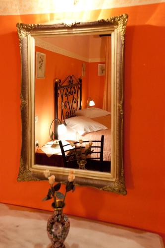a mirror in a room with a bed and a table at Pension Eleni in Nafplio