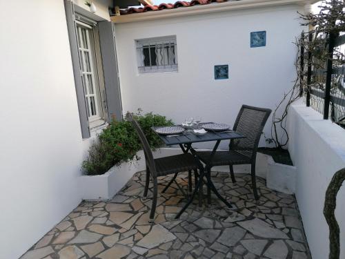 een tafel en stoelen op een terras bij Le Cottage in Rochefort