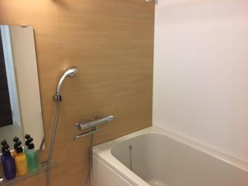 a shower in a bathroom with a bath tub at Alphabed Takamatsu Furujinmachi - Vacation STAY 11906 in Takamatsu